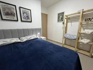 ein Schlafzimmer mit einem blauen Bett und einer Etagenbetten-Leiter in der Unterkunft Casa com 03 quartos proximo a rodoviaria in Uruguaiana