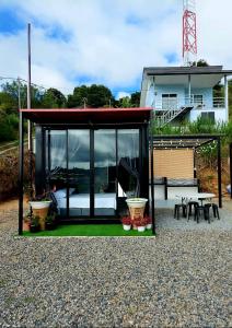 Casa pequeña con puertas de cristal, mesa y sillas en SF Homestay en Kundasang