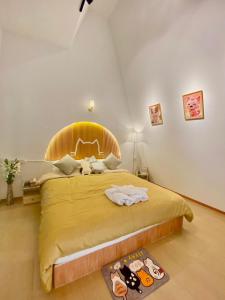 a bedroom with a large bed with a yellow bedspread at Zoo Villa บ้านน้องแมว in Nan