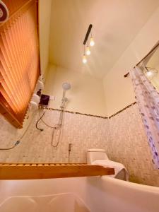a bathroom with a shower and a bath tub at Zoo Villa บ้านน้องแมว in Nan