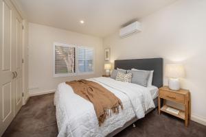 Un dormitorio con una cama grande y una ventana en Esplanade Escape to the Brighton Beach Boxes en Melbourne