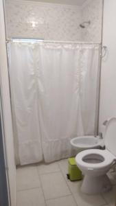 a bathroom with a toilet and a shower curtain at Casa en Gualeguaychú in Gualeguaychú