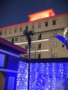 un hotel con luces azules frente a un edificio en ホテルハンズ en Ginan