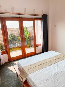 um quarto com 2 camas e uma grande janela em Turtle House Surf & Stay em Airsatang