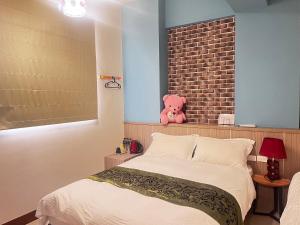 東港的住宿－東港怡然雅居民宿，一张床上的粉红色泰迪熊