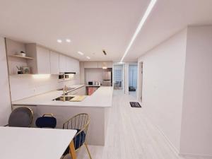 a kitchen with white cabinets and a counter and chairs at Sosaewool Avenue in Bucheon