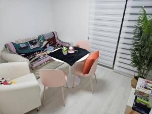 sala de estar con mesa, sillas y sofá en Sosaewool Avenue en Bucheon