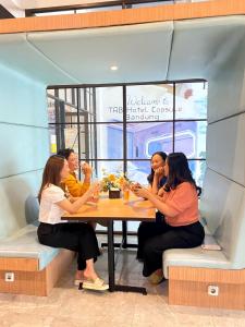 un groupe de femmes assises à une table dans un restaurant dans l'établissement TABHotel Capsule Bandung, à Bandung