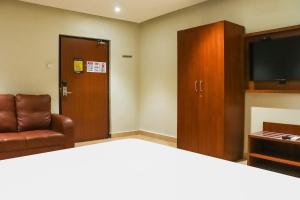 Habitación con cama, silla y armario en Hotel Kk Trends, en Vijayawāda