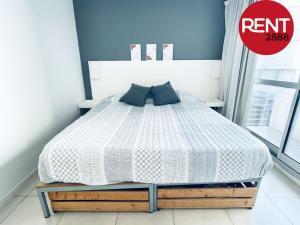1 dormitorio con 1 cama con edredón blanco en Rent Balcarce en Buenos Aires