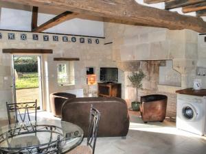 un soggiorno con tavolo in vetro e parete in pietra di Maison rénovée du XVIe, jardin clos, proche de la Loire et châteaux, tout inclus, équipements complets - FR-1-381-562 a La Chapelle-sur-Loire