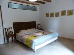 una camera da letto con un letto e una sedia di Maison rénovée du XVIe, jardin clos, proche de la Loire et châteaux, tout inclus, équipements complets - FR-1-381-562 a La Chapelle-sur-Loire