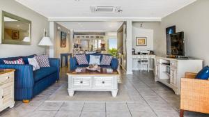a living room with a blue couch and a table at Waterfront 2-bed townhouse - Harbour 17 townhouse in Gros Islet