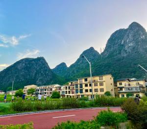 a street with buildings and mountains in the background at Guilin Meishe Homestay in Guilin
