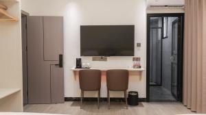 a room with two chairs and a bar with a television at Guilin Meishe Homestay in Guilin