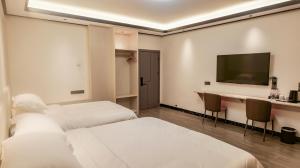Habitación de hotel con 2 camas y TV de pantalla plana. en Guilin Meishe Homestay, en Guilin