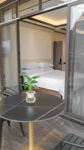 a bedroom with a bed and a table with a plant at Guilin Meishe Homestay in Guilin