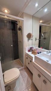 y baño con ducha, aseo y lavamanos. en Apartamento Praia Barra da Tijuca -Acolhedor e Confortável, en Río de Janeiro
