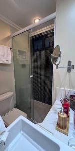 y baño con ducha, aseo y lavamanos. en Apartamento Praia Barra da Tijuca -Acolhedor e Confortável, en Río de Janeiro