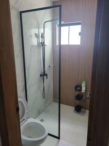 a bathroom with a toilet and a glass shower at Bella casa de playa Mar Adentro in Santa Cruz de la Sierra