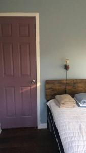 a bedroom with a purple door and a bed at Rock Pad AirBnB in New Haven