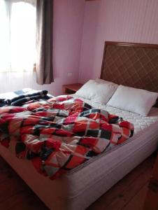 ein Bett mit einer bunten Decke in einem Schlafzimmer in der Unterkunft Cabañas Laguna Seca 