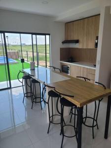 a kitchen with a wooden table and some chairs at Bella casa de playa Mar Adentro in Santa Cruz de la Sierra