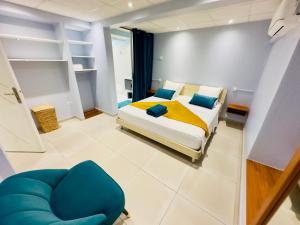 - une chambre avec un lit et une chaise bleue dans l'établissement Maison T3 Nid Bleu - Piscine Privée, au Marin