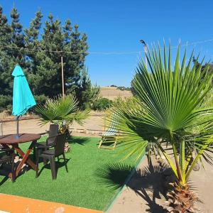 eine Terrasse mit einem Tisch, Stühlen und einem Sonnenschirm in der Unterkunft Cabañas Laguna Seca 