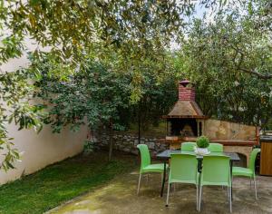 リメナリアにあるLa Verde Apartmentsの暖炉のある庭のテーブルと椅子