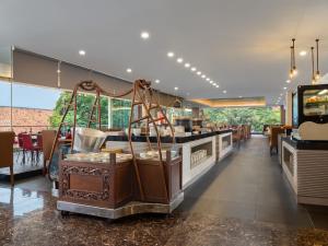 uma sala de jantar com um buffet e um bar em Hotel Santika Premiere Gubeng Surabaya em Surabaia