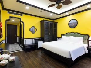 a bedroom with a white bed and a yellow wall at Charming beauty hotel in Da Nang