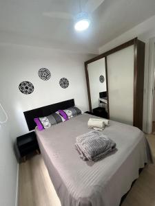 sypialnia z dużym łóżkiem z fioletowymi poduszkami w obiekcie Apto Allianz Metrô Barra Funda w São Paulo