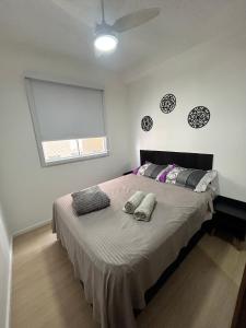 una camera da letto con un grande letto con due cuscini sopra di Apto Allianz Metrô Barra Funda a San Paolo