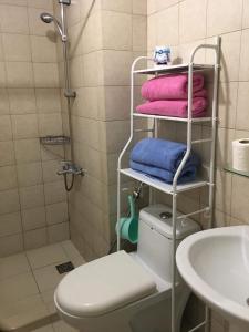 a bathroom with a towel rack next to a toilet at GREENFIELD studio w/ 2 queen across Shangrila in Manila