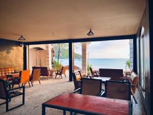 un restaurante con mesas y sillas y vistas al océano en CORAL en Koh Rong Sanloem