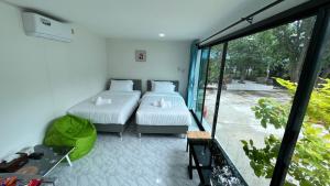 2 camas en una habitación con ventana grande en Pattaya Golden view pool villa, en Ban Nong Srah
