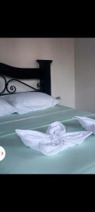 a bed with two white towels on top of it at Habitaciones sierpe de osa in Sierpe