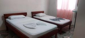 two beds in a room with towels on them at Habitaciones sierpe de osa in Sierpe