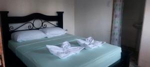 a bed with two white flowers on it at Habitaciones sierpe de osa in Sierpe