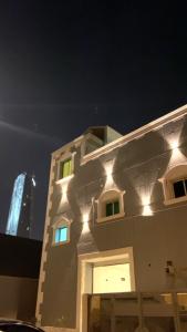 a building with lights on the side of it at night at الرياض حي العقيق in Riyadh