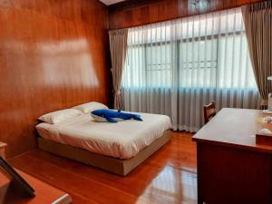 um quarto com uma cama com um objecto azul em Whales Come to the River - Riverside - 3 rooms on 2nd floor em Ban Bang Phli Nua