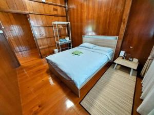 um quarto com uma cama e piso em madeira em Whales Come to the River - Riverside - 3 rooms on 2nd floor em Ban Bang Phli Nua