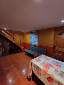 Habitación con mesa, sofá y escalera. en Casa en Valdivia, en Valdivia