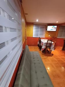 comedor con sofá, mesa y TV en Casa en Valdivia, en Valdivia
