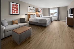 a hotel room with two beds and a couch at Hawthorn Extended Stay by Wyndham Williston Burlington in Williston +22 photos