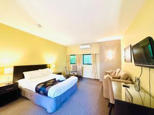 a hotel room with a bed and a flat screen tv at Comfort Inn & Suites City Views in Ballarat