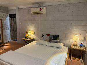 um quarto com uma grande cama branca e 2 candeeiros em Charm Villas em Bà Rịa