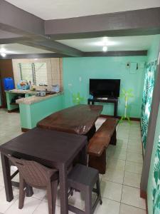 a kitchen with a table and benches in a room at Baloy beach house in Olongapo