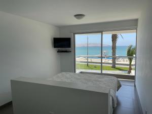 a bedroom with a bed and a view of the ocean at Ocean View Apartment in Paracas